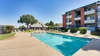 Pool in front of white brown building